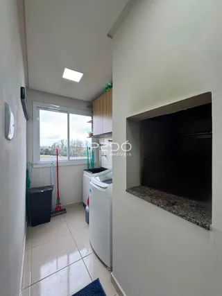 Vista de um corredor interno com piso de cerâmica e parede branca.