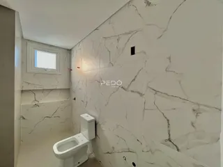 Corredor interno com revestimento de parede em mármore branco.