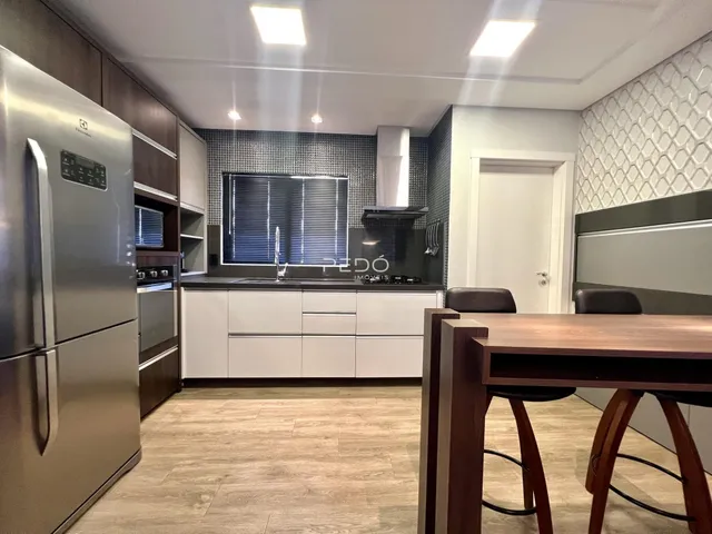 Foto de uma cozinha moderna com armários brancos e piso de madeira clara.