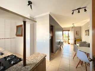 A cozinha e a área comum estão integradas em um ambiente claro.
