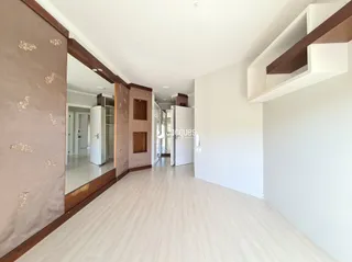 Ambiente interno de uma residência com piso de madeira clara.