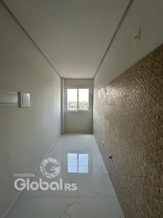 Corredor interno de uma residência com piso de mármore e parede texturizada.