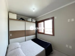 Quarto com cama e armário em um ambiente claro.