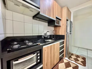 Cozinha moderna com armários de madeira e bancada escura.