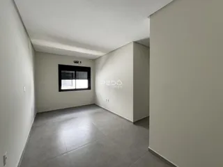Corredor interno com paredes brancas e piso cinza.