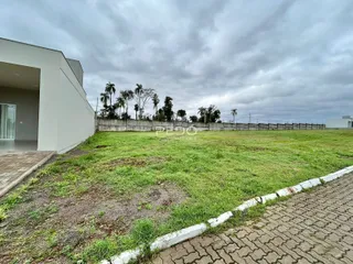 Vista da fachada de uma residência com um grande terreno gramado.
