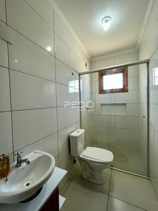 Foto de um banheiro com azulejos brancos e box de vidro.