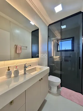 Foto de um banheiro moderno com bancada branca e box de vidro.