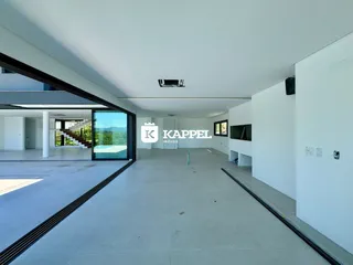 Vista interna de um ambiente amplo com piso claro e porta de vidro.