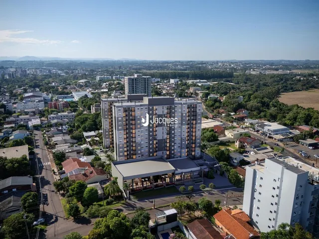 Vista aérea de uma área residencial em Lajeado, Brasil, mostrando diversas construções e vegetação.