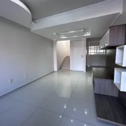 Vista de um corredor interno com paredes brancas e piso claro.