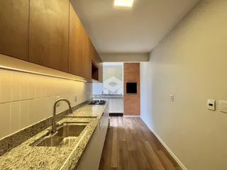 Cozinha com armários de madeira e bancada de granito.