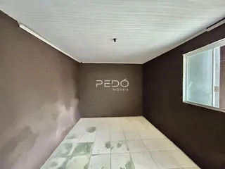 Foto interna de um cômodo com piso de azulejos claros e paredes escuras.