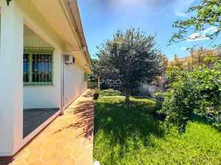 Fachada de uma residência em Lajeado, Brasil, com jardim gramado e calçada de tijolos.