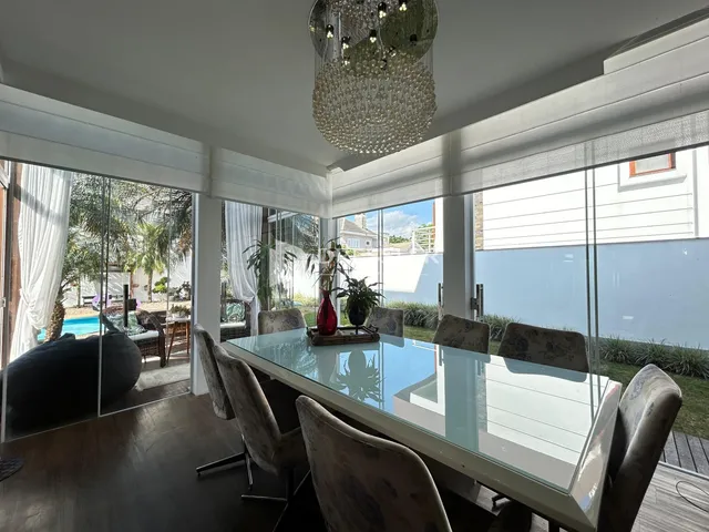 Uma sala de jantar com vista para o exterior e jardim.