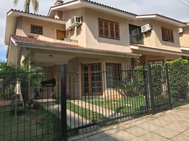 Fachada de uma casa residencial em Lajeado, Brasil, com cerca e jardim na frente.