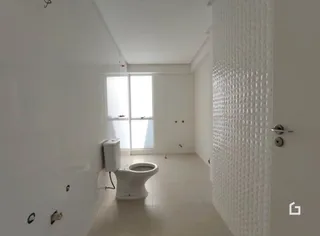 Foto de um banheiro com piso claro e paredes brancas.