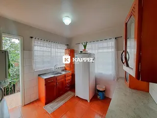 Cozinha com armários de madeira e piso de cerâmica.