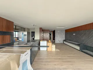 Vista da cozinha com armários e piso de madeira em um imóvel no Brasil.