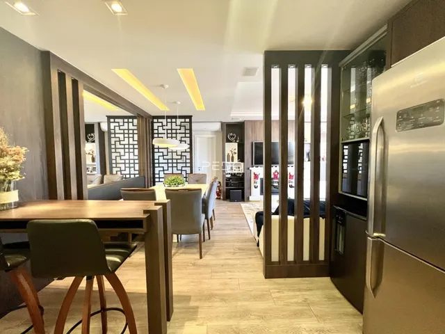 Interior de uma sala de estar e jantar moderna com piso de madeira clara.