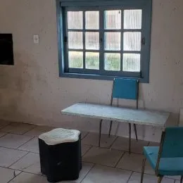 Foto de um ambiente interno com uma mesa e cadeiras.