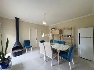 Sala de jantar com mesa e cadeiras em um imóvel no Brasil.