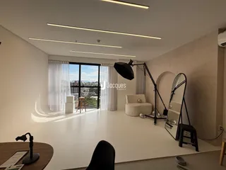 Uma sala de estar moderna com grandes janelas que oferecem uma vista da paisagem.