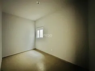 Ambiente interno de uma sala vazia com paredes brancas e piso claro.