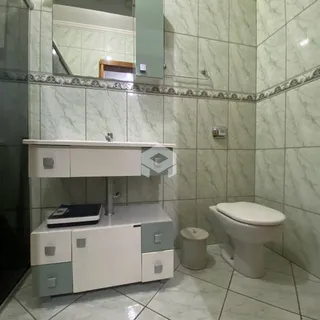 Foto de um banheiro com revestimento de azulejos claros.
