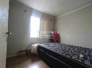 Quarto com cama visível na sala.