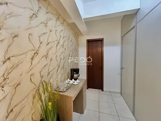 Hall com papel de parede em mármore e porta de madeira.