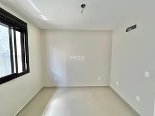 Vista interna de um ambiente com paredes brancas e piso claro.