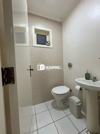 Foto de um banheiro com piso de cerâmica e vaso sanitário branco.