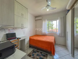 Quarto com cama e armários brancos na residência.