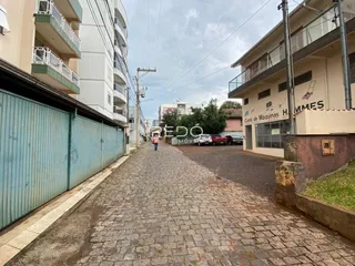 Vista da rua de paralelepípedos entre edifícios residenciais em Lajeado.