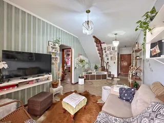 Sala de estar com decoração de parede listrada e piso de madeira.