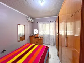 Quarto com cama e guarda-roupa de madeira.