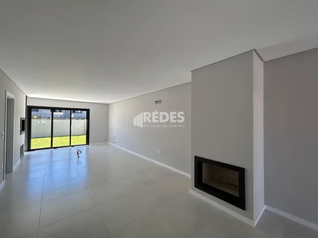Uma vista interna de uma sala ampla com paredes brancas.