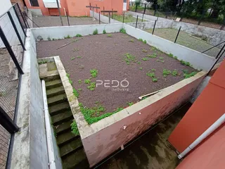 Vista de um terreno com paredes de concreto e jardim.