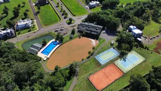 Vista aérea de uma propriedade em Lajeado, mostrando uma piscina e quadras de tênis.