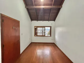 Interior de uma sala com piso de madeira e teto de madeira.