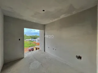 Interior de um espaço em construção com paredes de concreto.