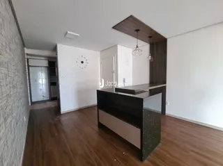 Interior de uma sala com piso de madeira e móveis de madeira escura.