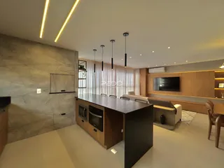 Uma sala de estar moderna com ilha de cozinha e painéis de madeira.