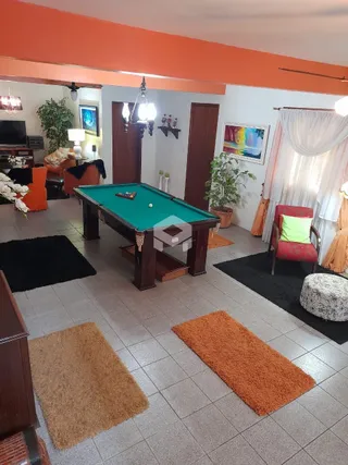 Sala de estar com mesa de bilhar no interior da residência.