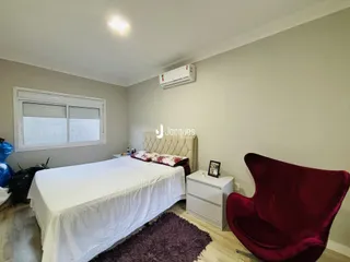 Quarto com cama e poltrona em ambiente claro.