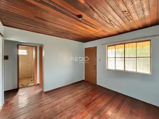 Sala de estar com piso de madeira e teto de madeira aparente.