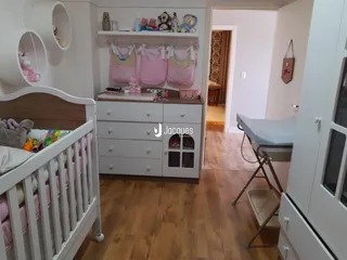 Quarto com cabeceira de madeira e armários brancos.