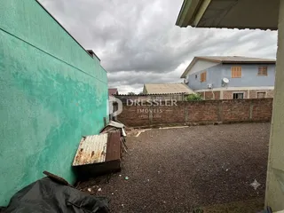 Fachada de uma residência em Lajeado, Brasil, com parede verde e muro de tijolos.