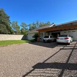 Foto da fachada de uma residência em Lajeado, Brasil, com um pátio de cascalho.